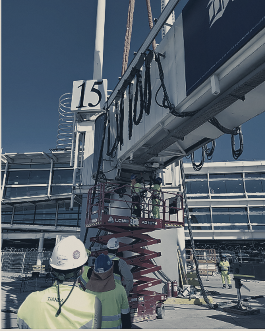 Cuadrilla de APS instalando una pasarela de embarque de pasajeros en un aeropuerto