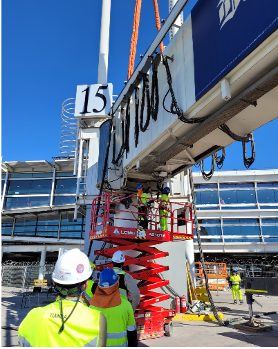 Cuadrilla técnica de APS LATAM instalando una pasarela de embarque en la puerta 15 de un aeropuerto